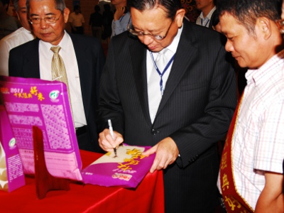 黃副主委在呂理文（右一）獲獎的好米上簽名留念